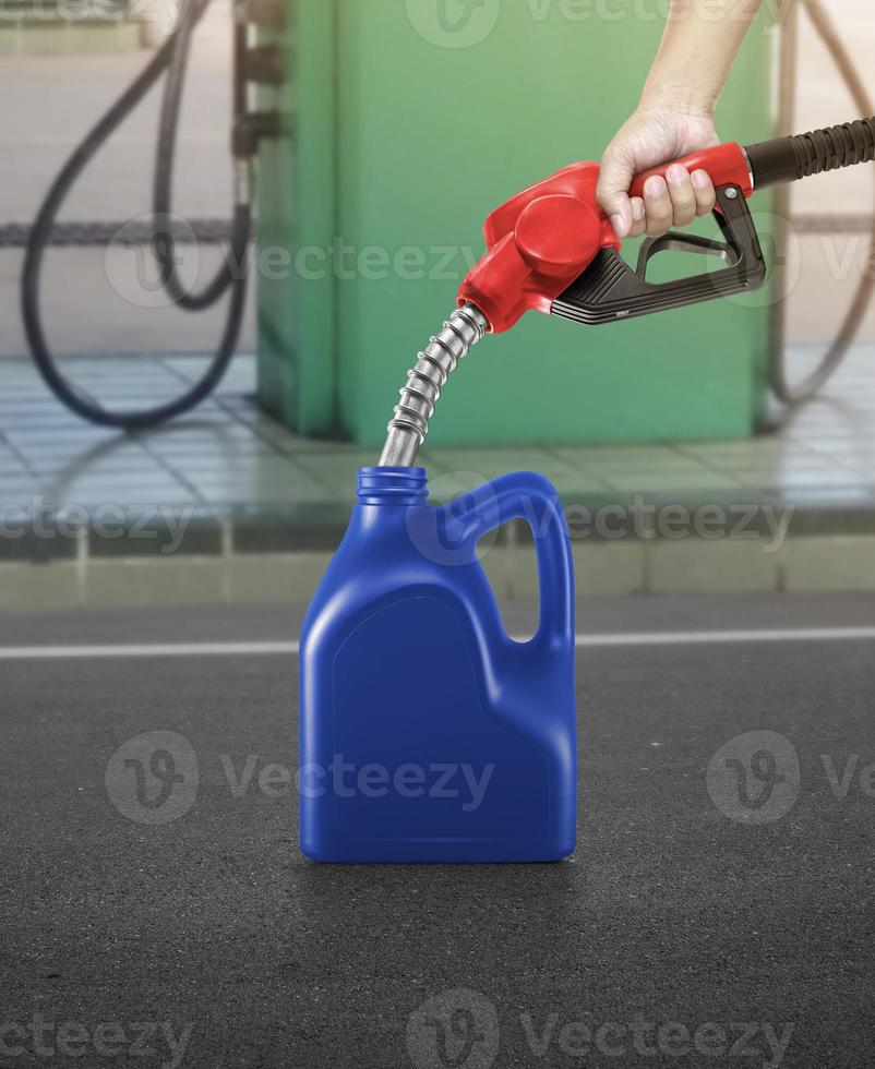 um homem enche jerry cans em um posto de gasolina foto