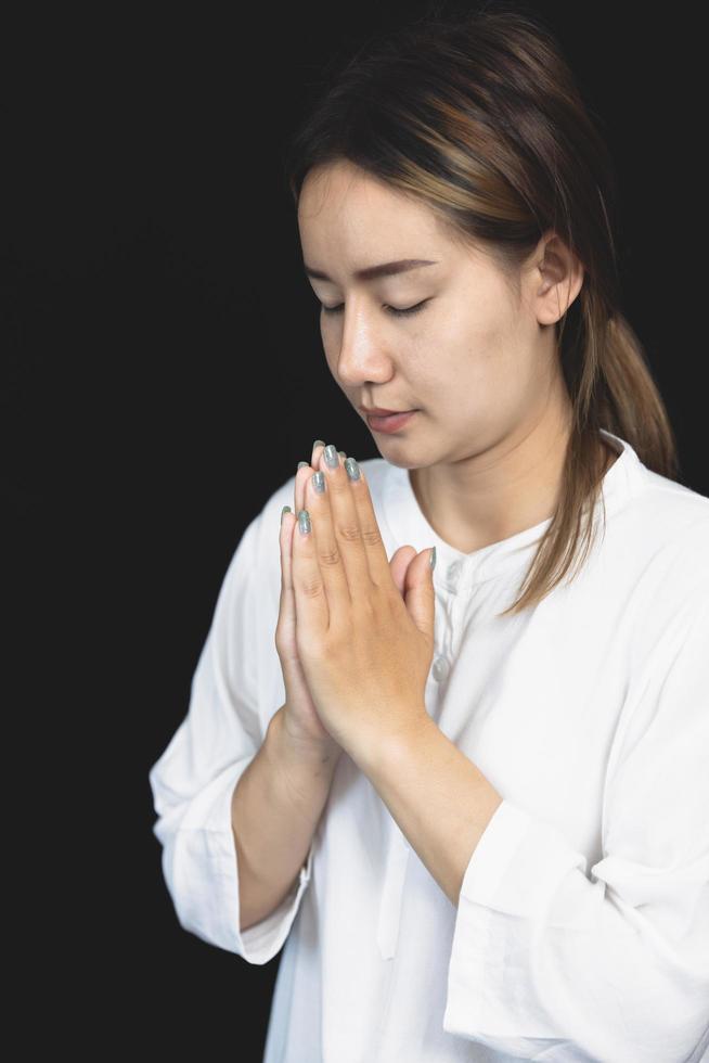 mulher rezando as mãos com fé na religião e crença em Deus no fundo do nascer do sol da manhã. gesto de mãos namaste ou namaskar, respeito, posição de oração. foto