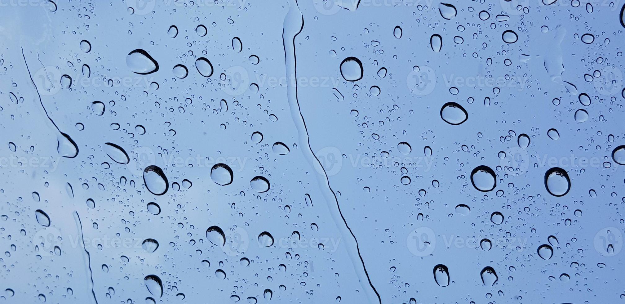 perspectiva de gotas de água através da superfície do vidro da janela contra o céu azul bom para conteúdo multimídia foto