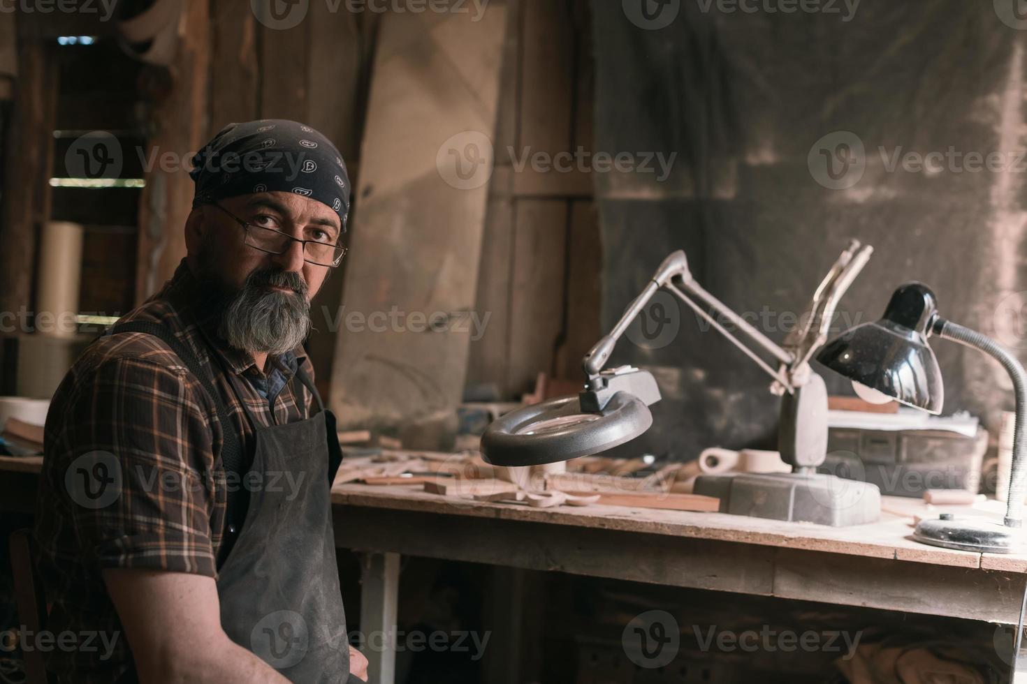 mestre colher em sua oficina com ferramentas e produtos de madeira foto