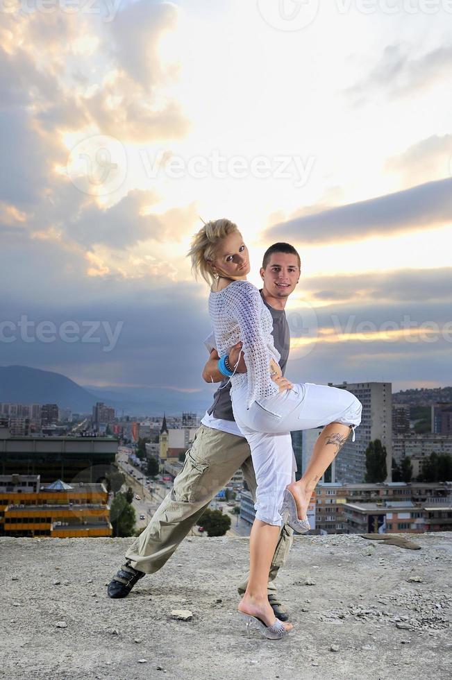 casal urbano romântico dançando em cima de bulding foto