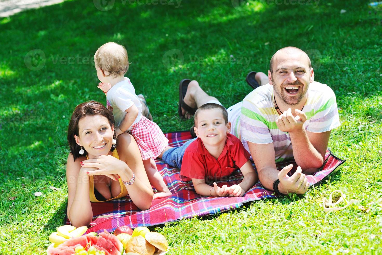 casal jovem feliz com seus filhos se divertir no parque foto