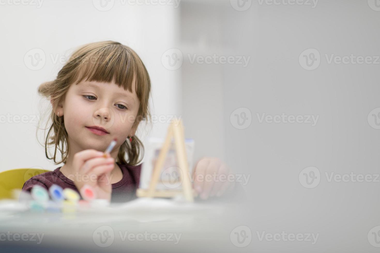 menina pintando em tela foto