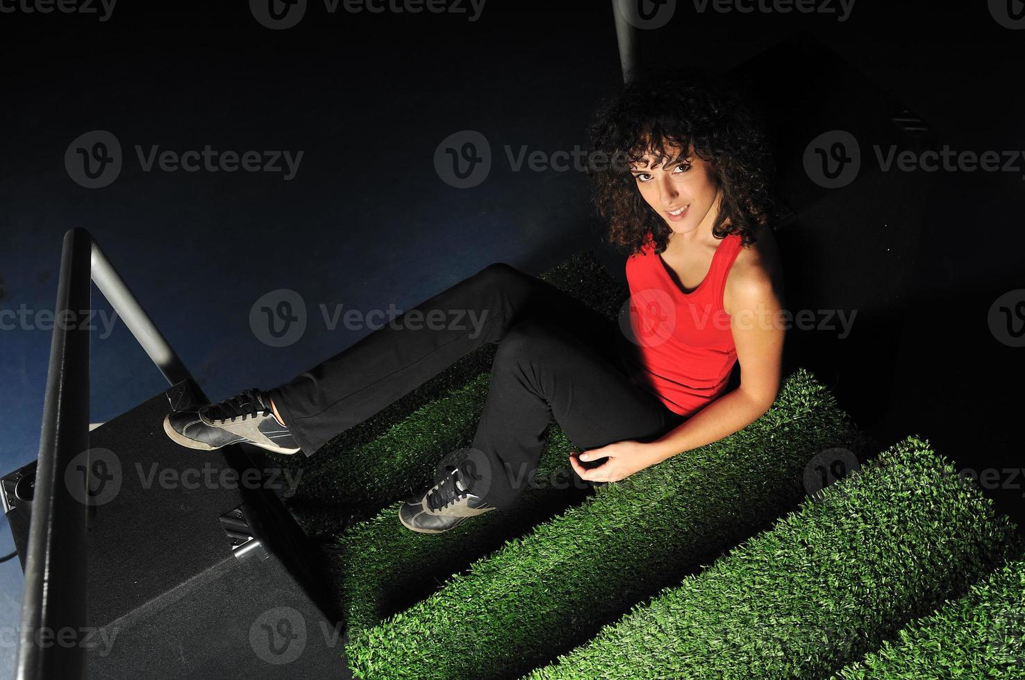 jovem relaxa nas escadas verdes com superfície de grama foto