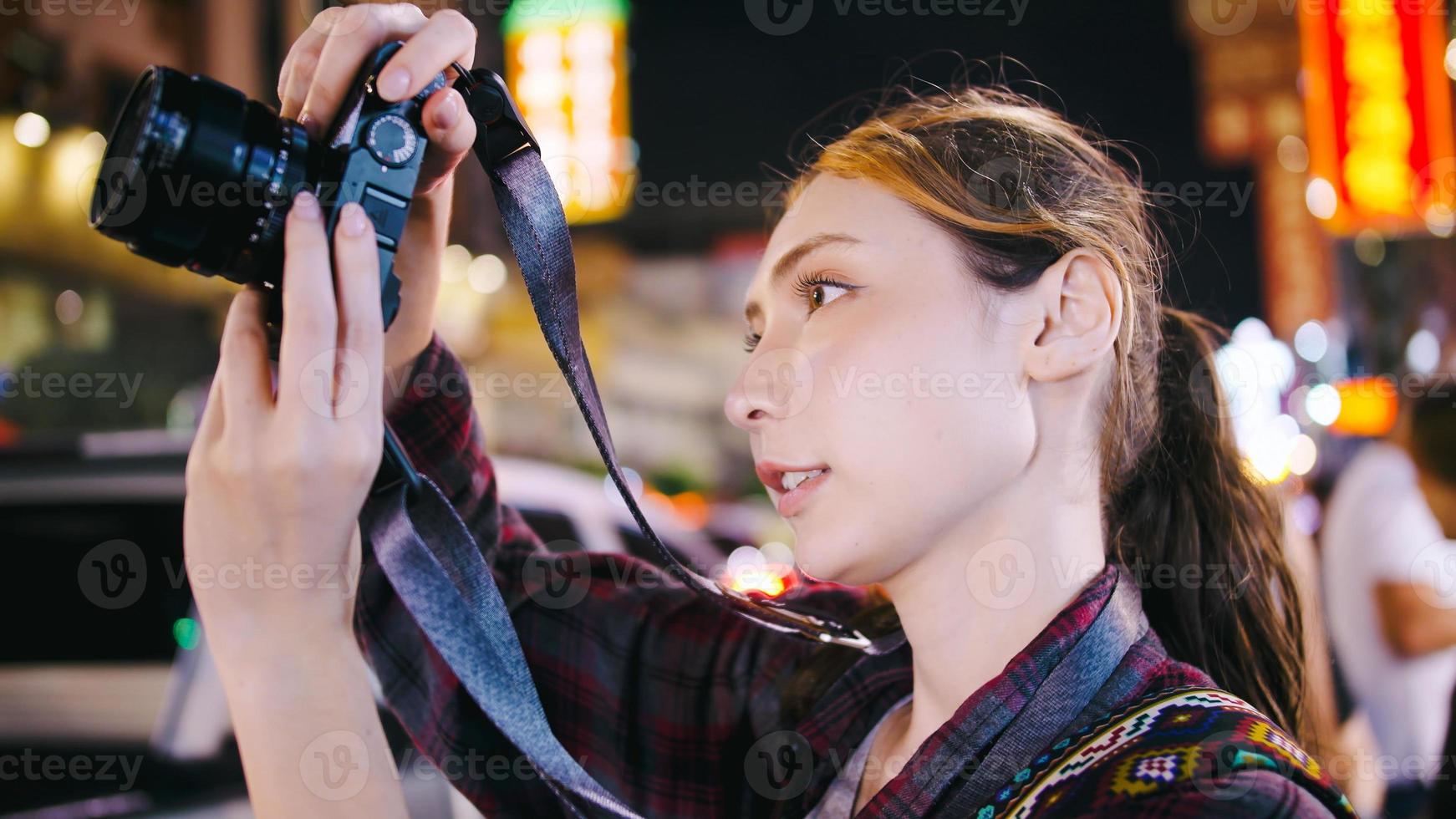 uma turista feminina gosta de tirar fotos da visão noturna da estrada yaowarat ou chinatown em bangkok, tailândia.