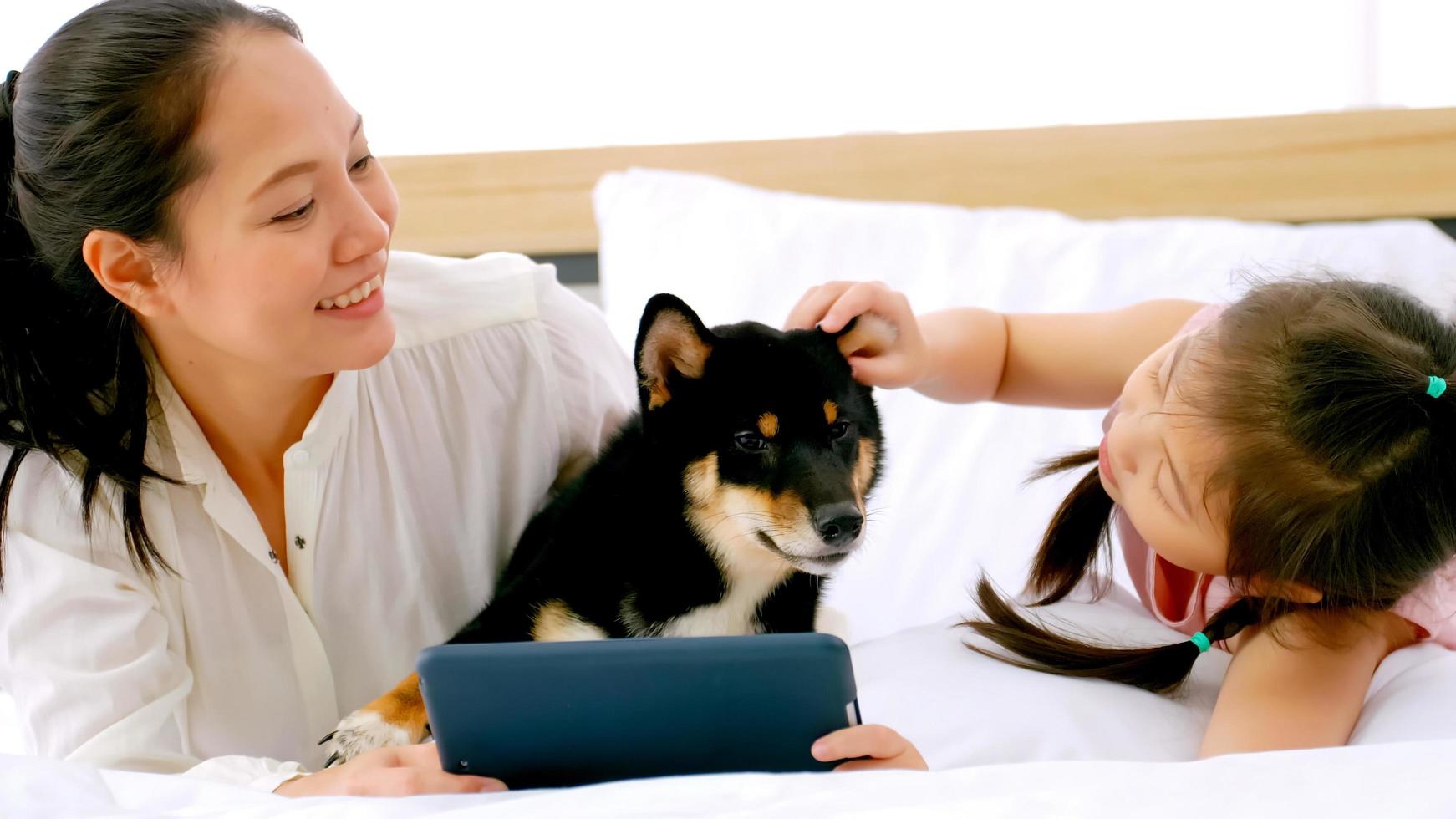 mãe e filha com seu cachorro passando tempo juntos em casa. foto