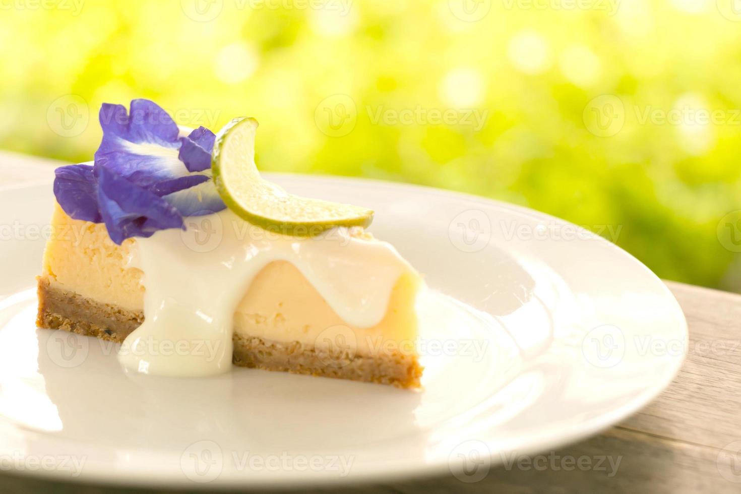 um pedaço de torta de queijo de limão deliciosa em chapa branca na mesa de madeira. foto
