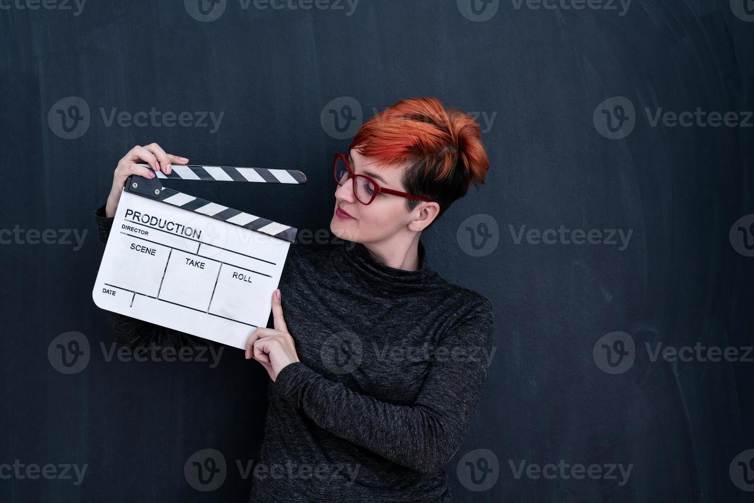 mulher ruiva segurando badalo de filme foto