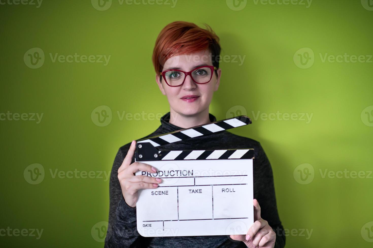 mulher segurando badalo de filme contra fundo verde foto