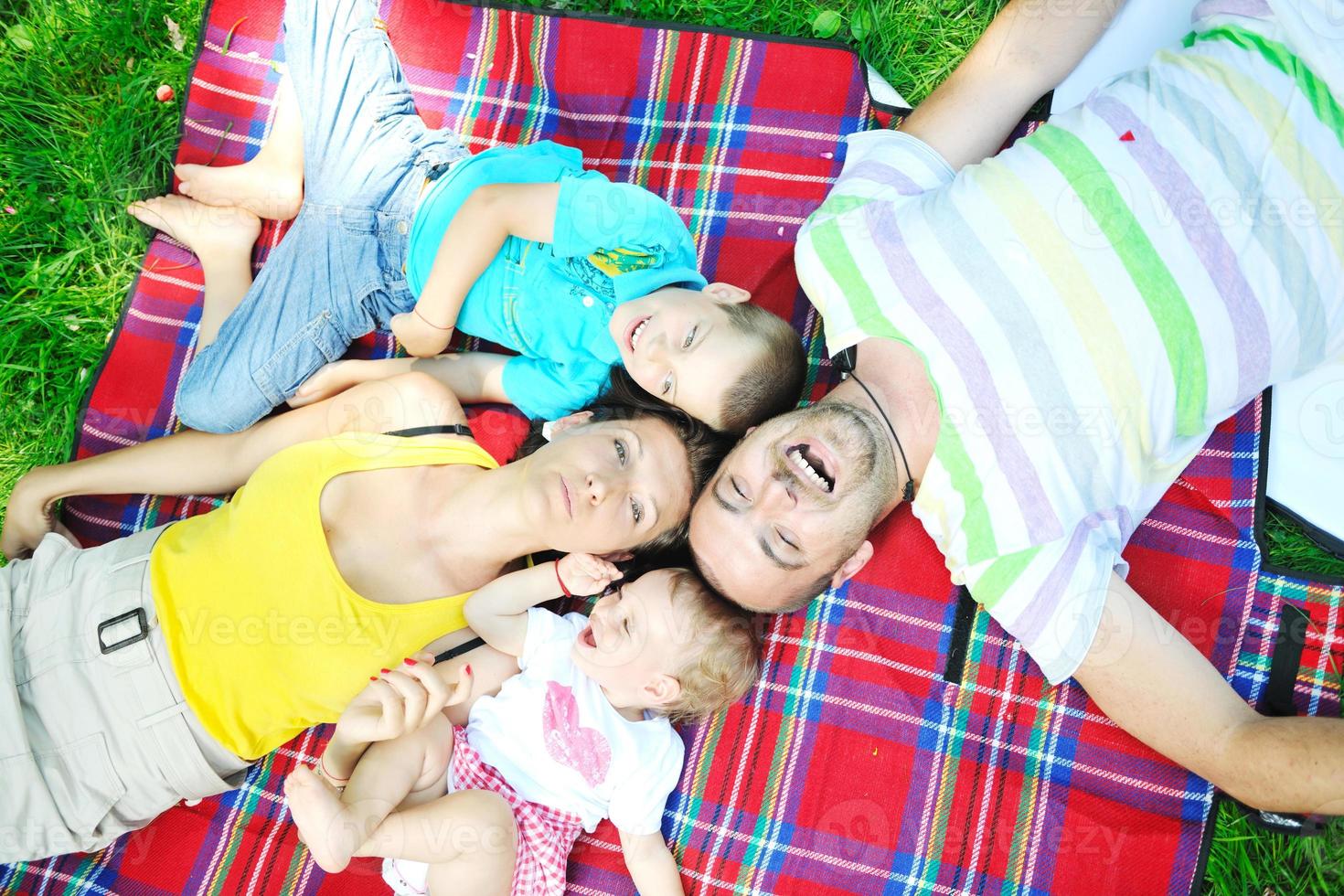 casal jovem feliz com seus filhos se divertir no parque foto