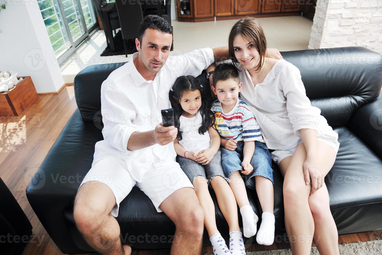 família assistindo tv plana em casa moderna interior foto