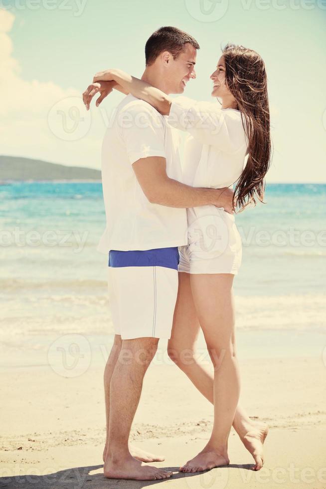 casal feliz se diverte na praia foto