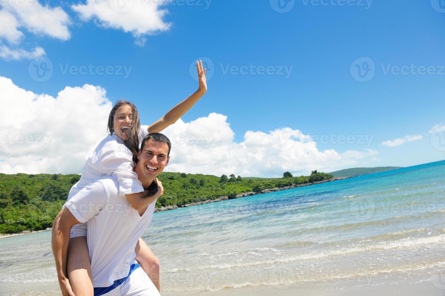 casal feliz se diverte na praia foto