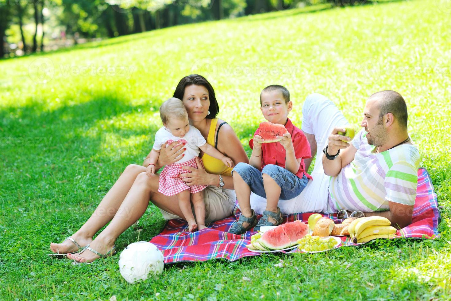 casal jovem feliz com seus filhos se divertir no parque foto