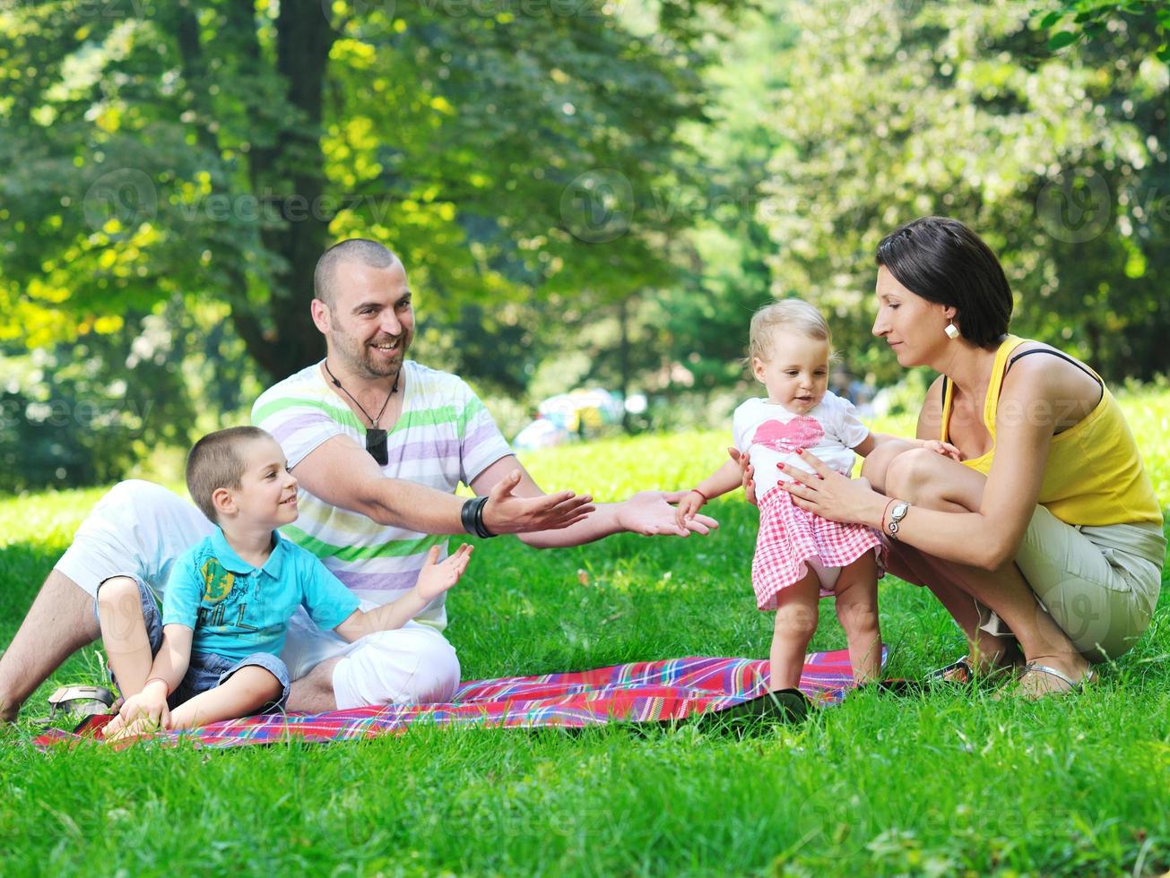 casal jovem feliz com seus filhos se divertir no parque foto