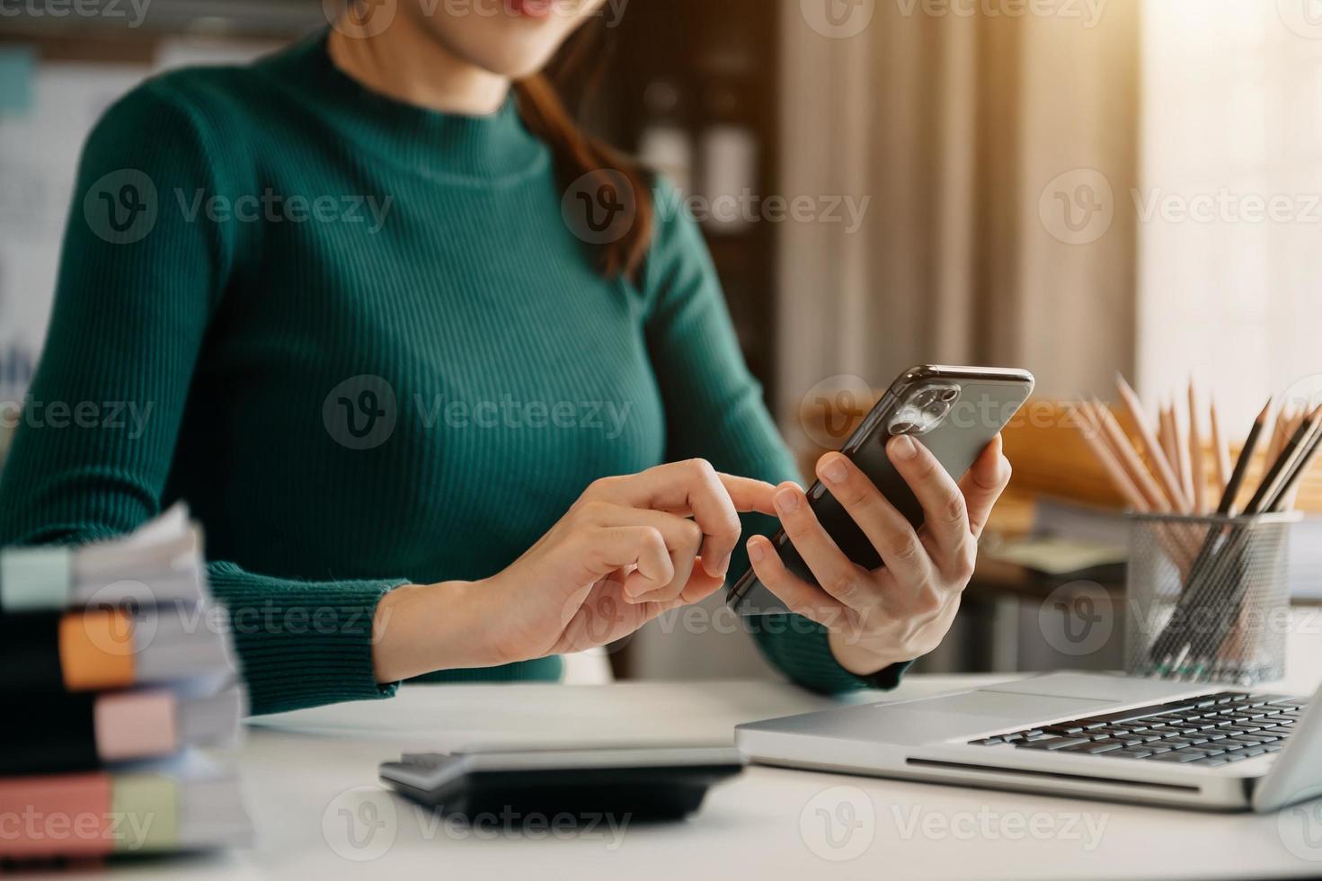 mão de empresária trabalhando mídia de marketing digital em tela virtual com telefone celular e computação moderna foto