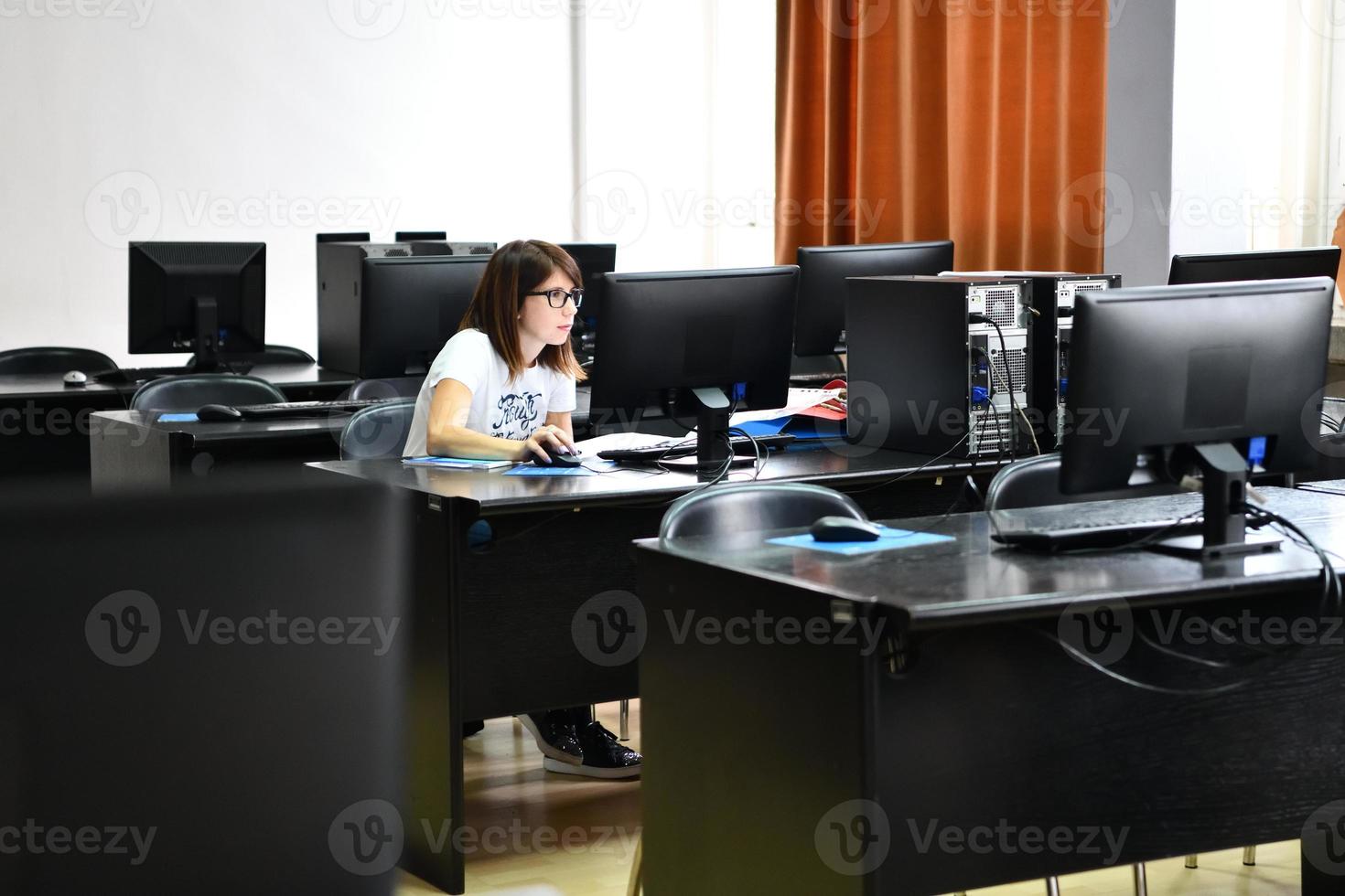 um aluno na sala de aula de computadores foto