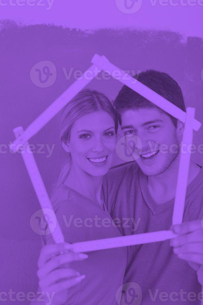 casal feliz pinta parede em casa nova foto