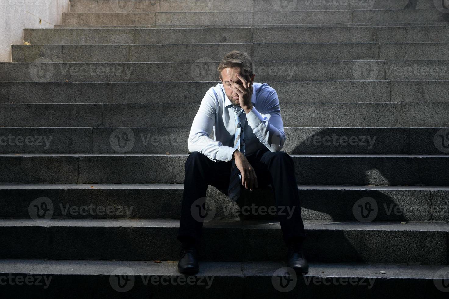 empresário chorando perdido em depressão, sentado na rua escadas de concreto foto