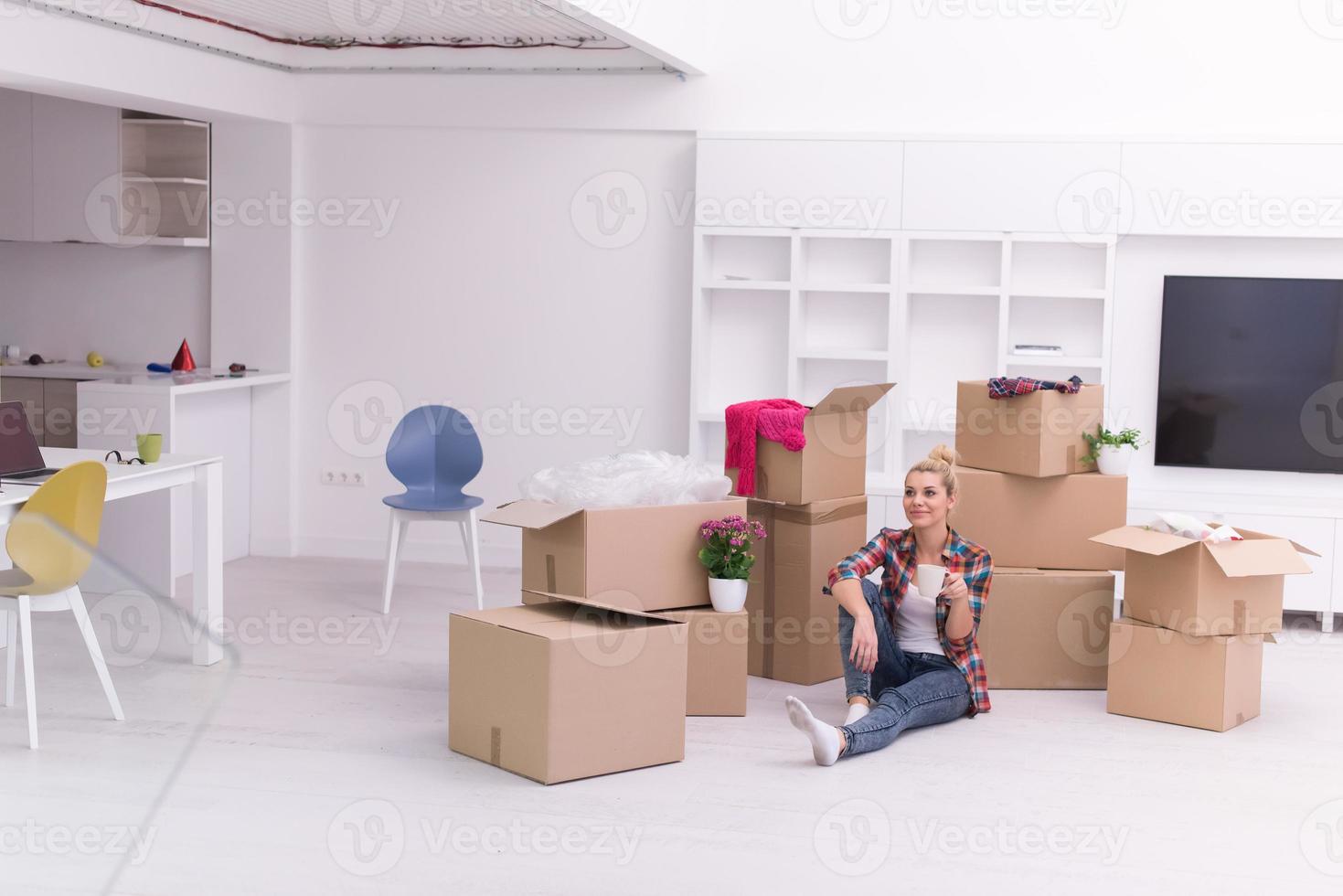 mulher com muitas caixas de papelão sentadas no chão foto