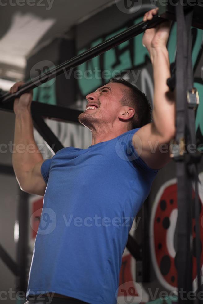 homem fazendo pull ups foto