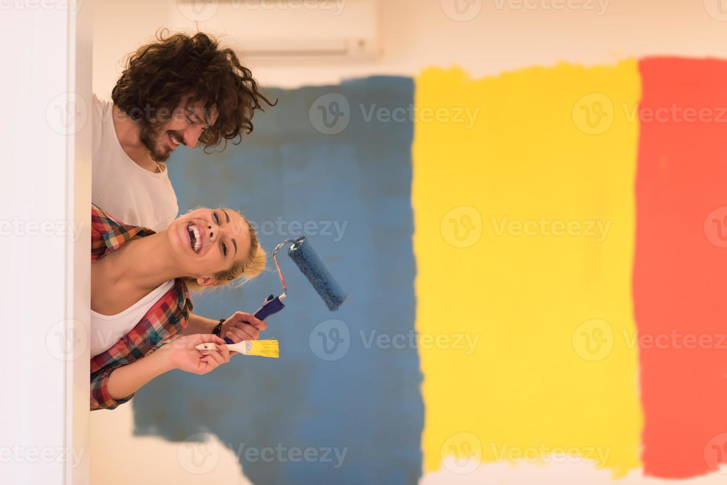 retrato de um casal pintando parede interior foto