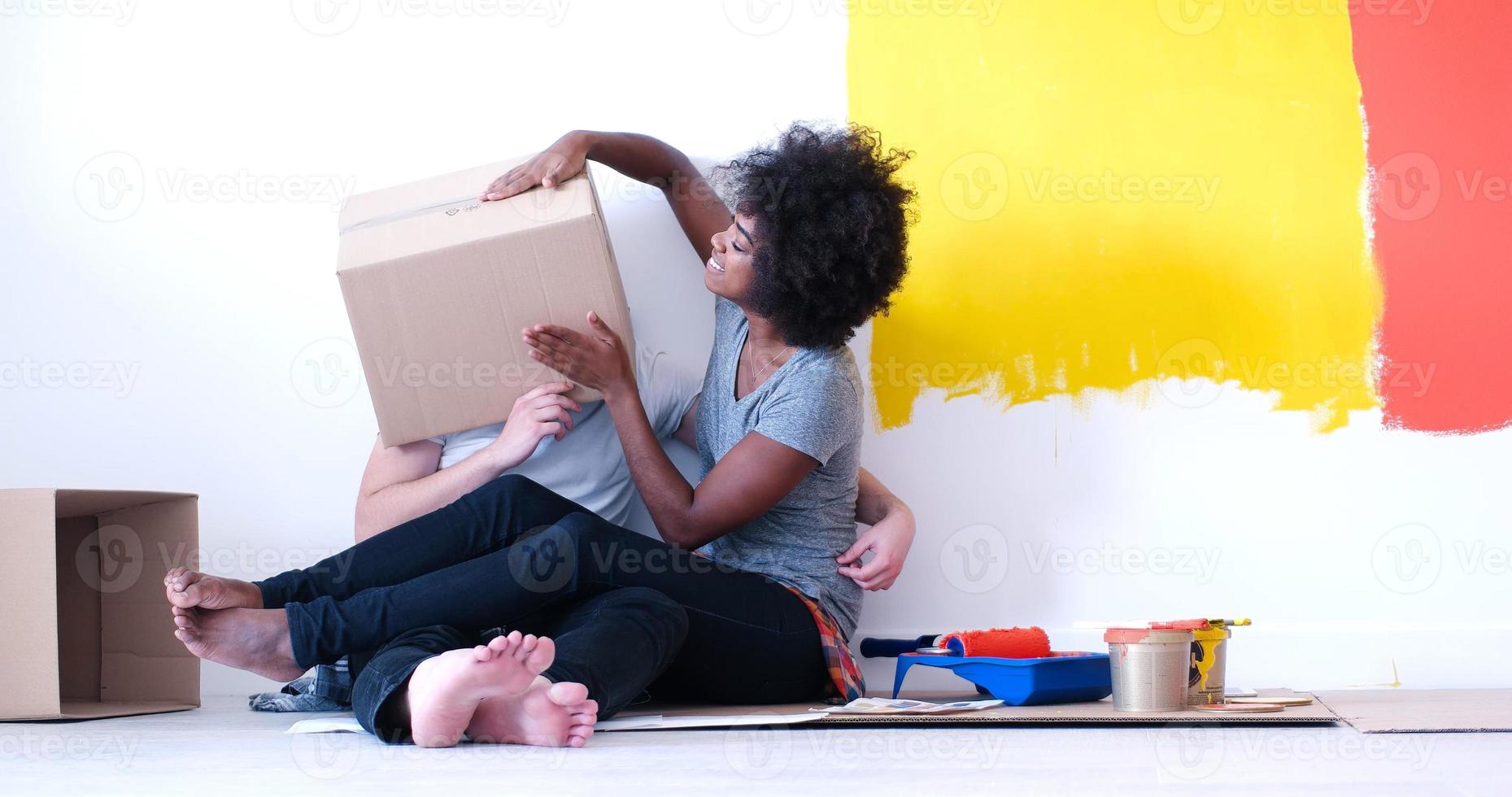 jovem casal multiétnico brincando com caixas de papelão foto