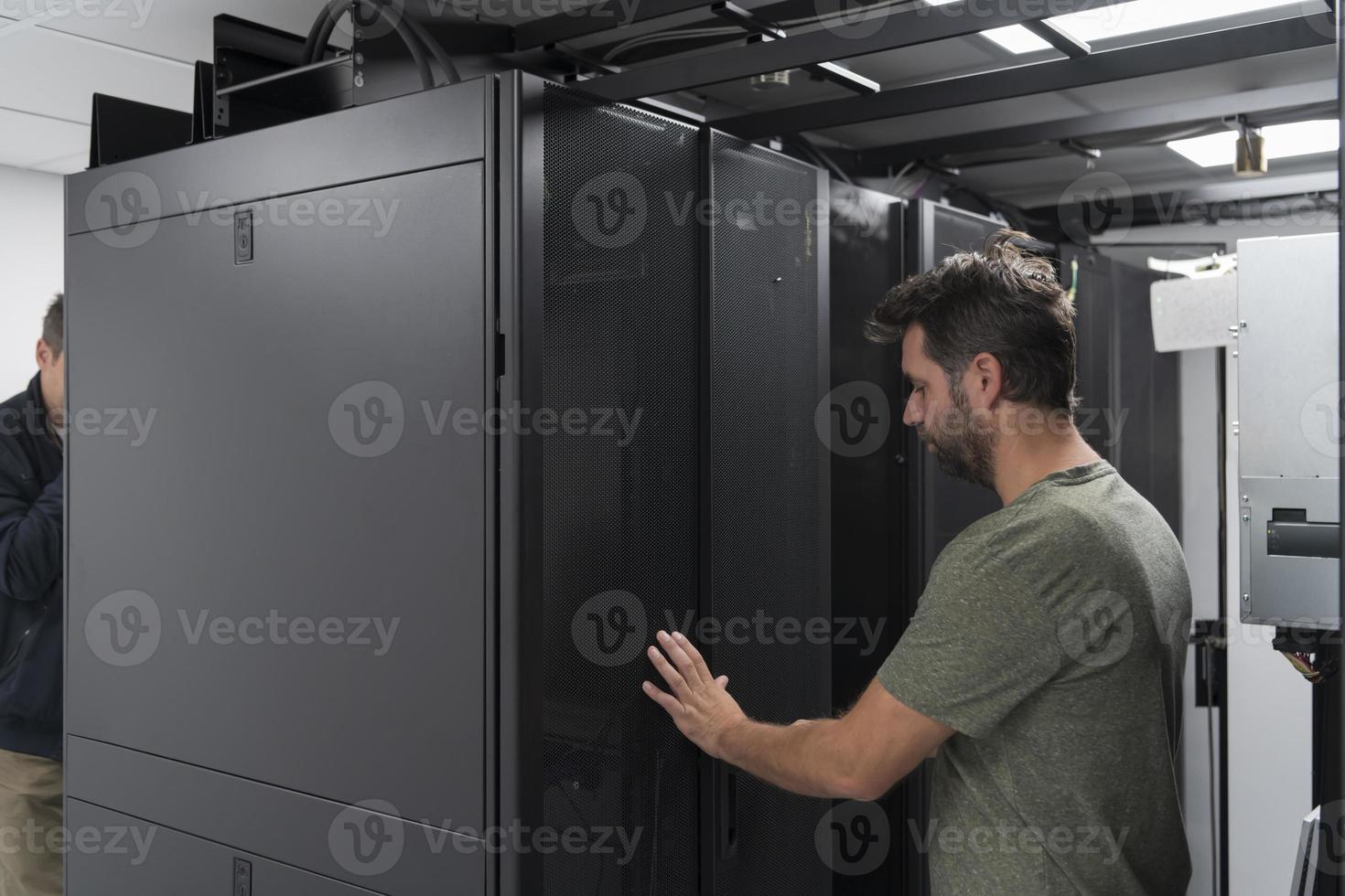 equipe de técnicos atualizando hardware inspecionando o desempenho do sistema na sala do supercomputador ou fazenda de mineração de criptomoedas. foto