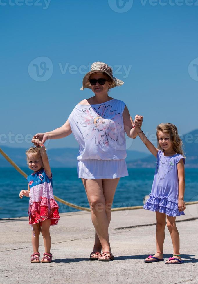 retrato de uma avó com suas netinhas fofas à beira-mar foto