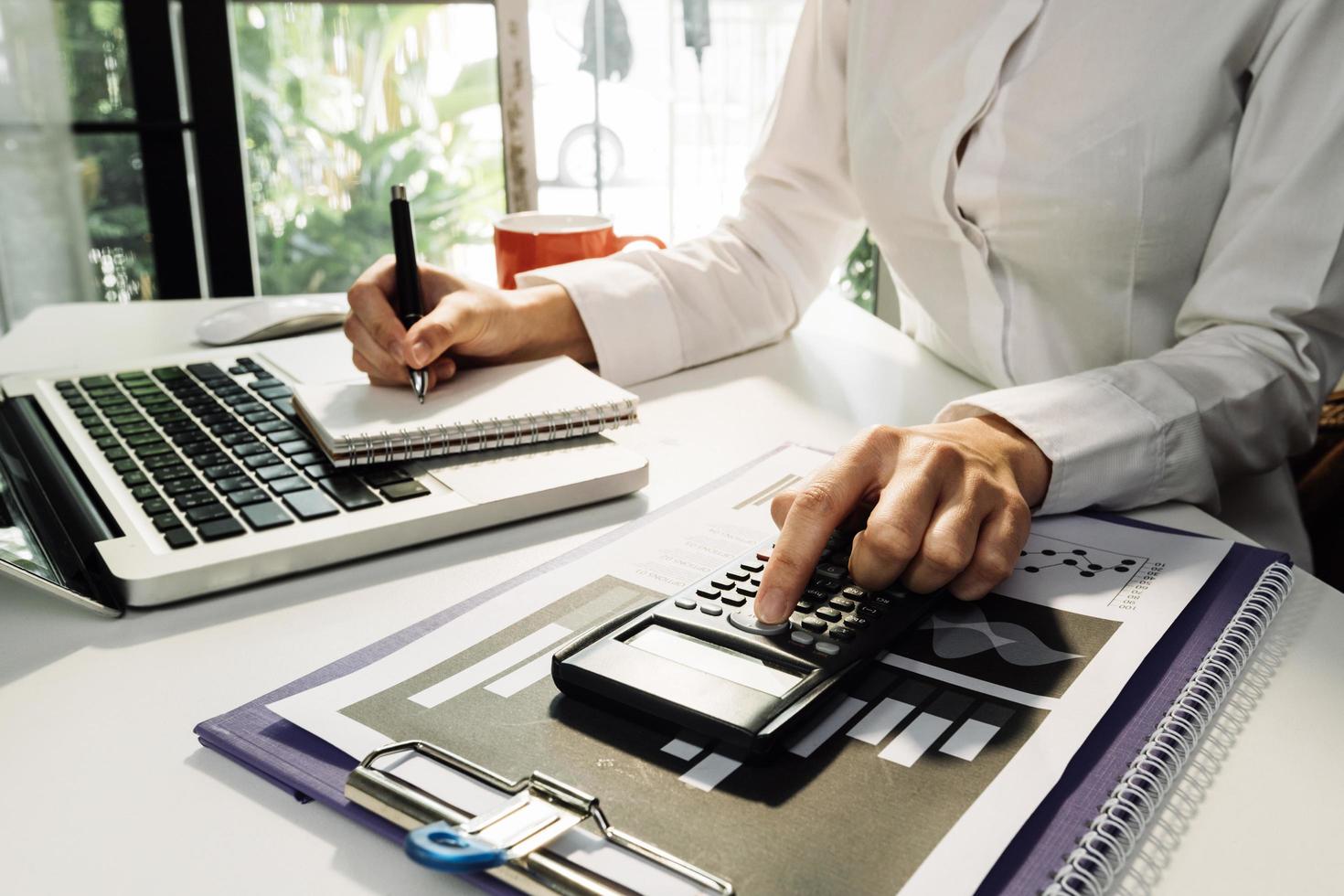 conceito de contabilidade empresarial, homem de negócios usando calculadora com computador portátil, orçamento e papel de empréstimo no escritório. foto