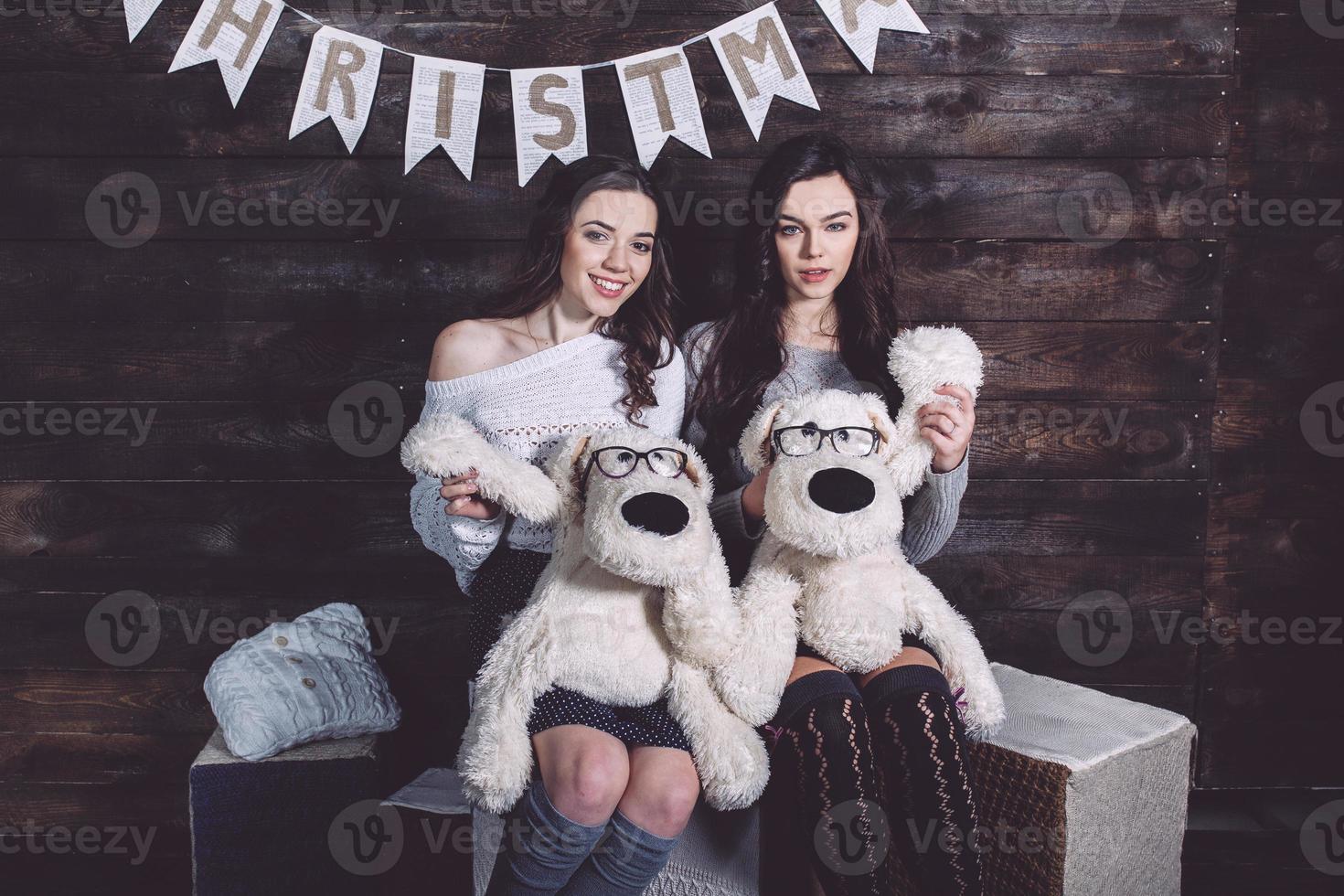 duas garotas encantadoras brincando com brinquedos de natal foto