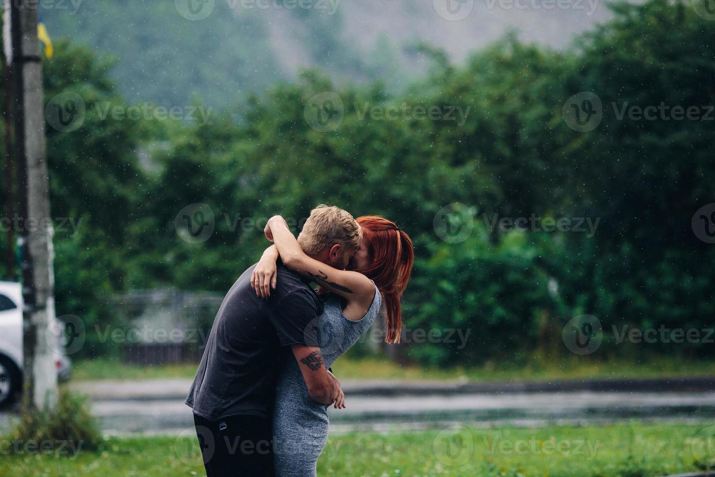 lindo casal abraçando na chuva foto