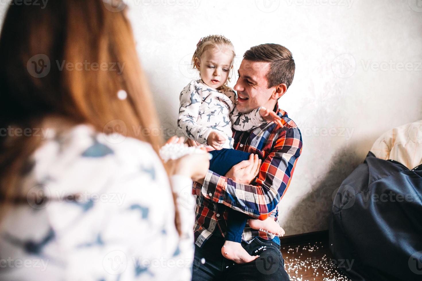 família feliz jogando juntos no chão foto