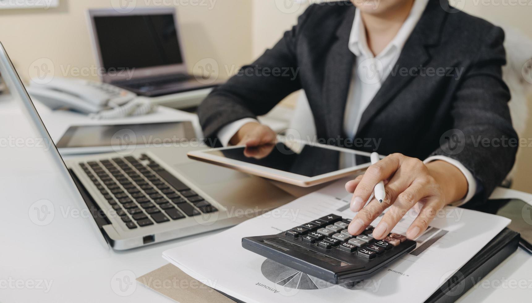 conceito de contabilidade empresarial, homem de negócios usando calculadora com computador portátil, orçamento e papel de empréstimo no escritório. foto