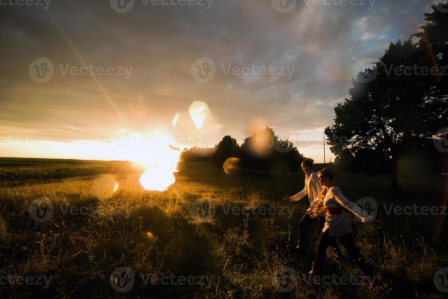 casal correndo para o pôr do sol foto