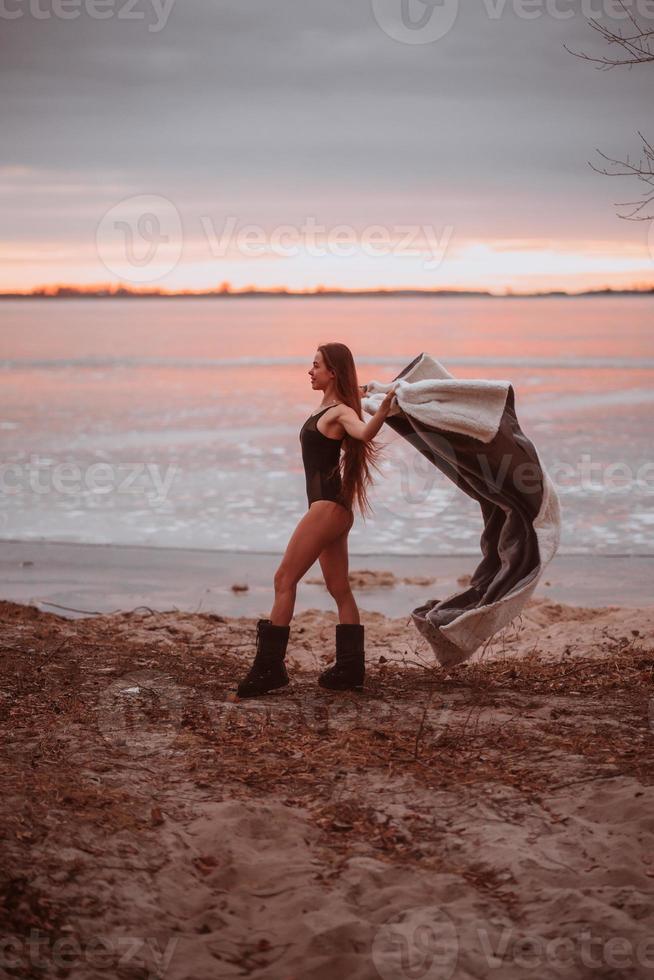 linda garota de maiô na margem de um lago congelado foto