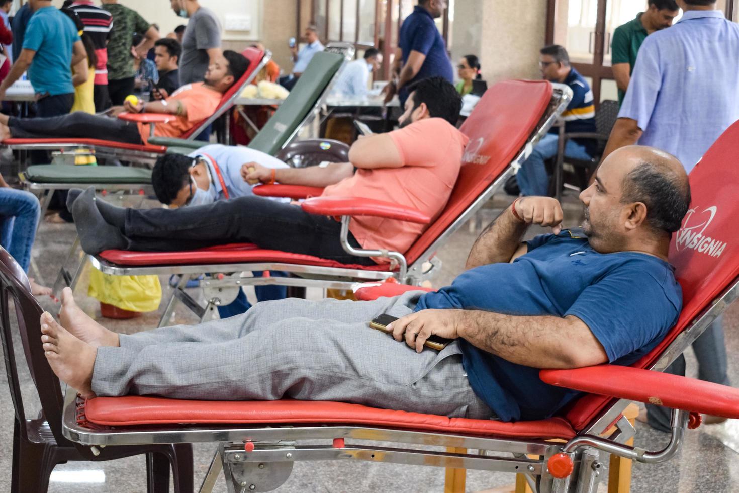 delhi, índia, 19 de junho de 2022 - doador de sangue no campo de doação de sangue realizado no templo balaji, vivek vihar, delhi, índia, imagem para o dia mundial do doador de sangue em 14 de junho de cada ano, campo de doação de sangue no templo foto