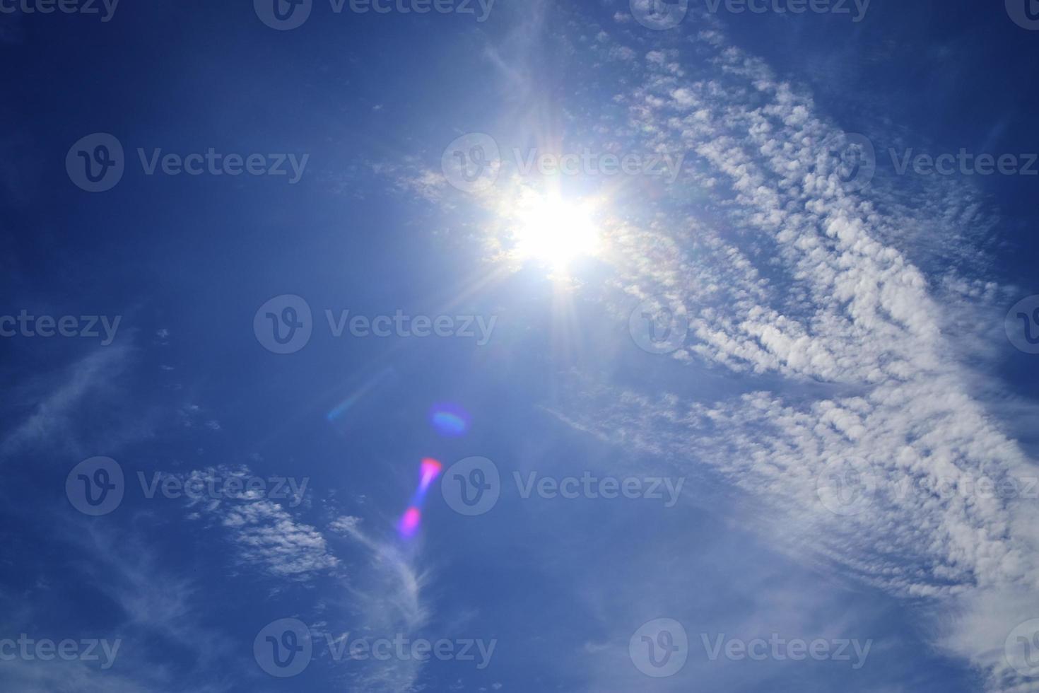 bela vista em raios de sol com alguns reflexos de lente e nuvens em um céu azul foto