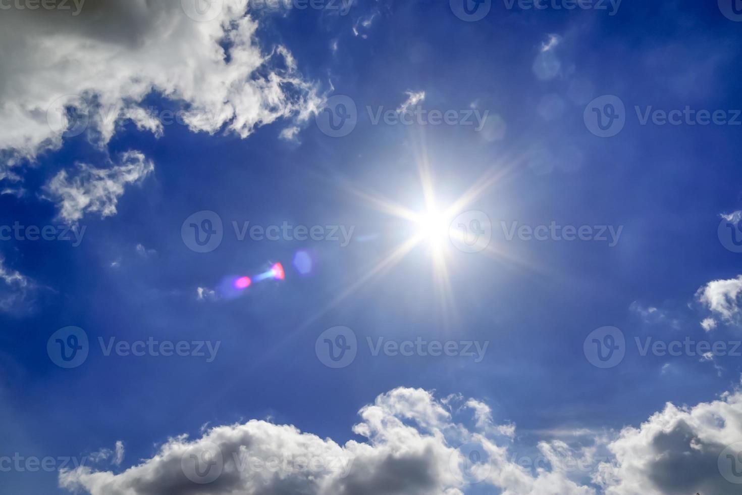 bela vista em raios de sol com alguns reflexos de lente e nuvens em um céu azul foto