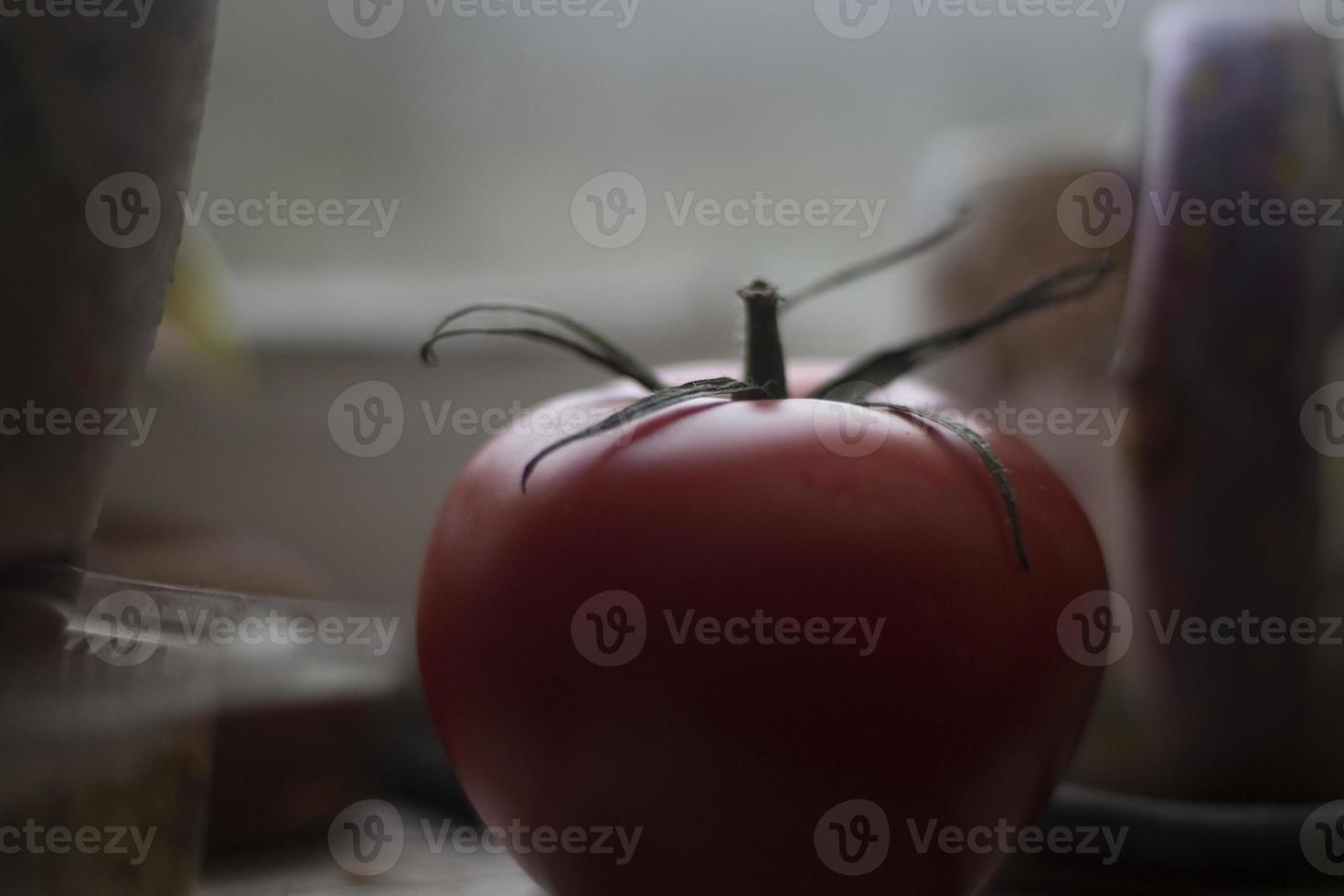 tomate vermelho. vegetais frescos. planta de jardim na mão. fruta madura na luz da janela. foto