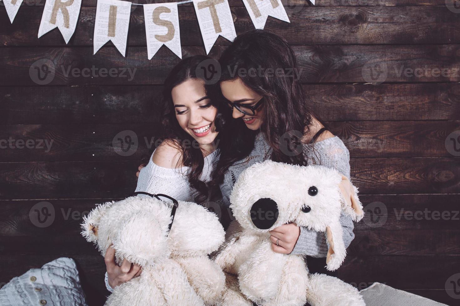 duas garotas encantadoras brincando com brinquedos de natal foto