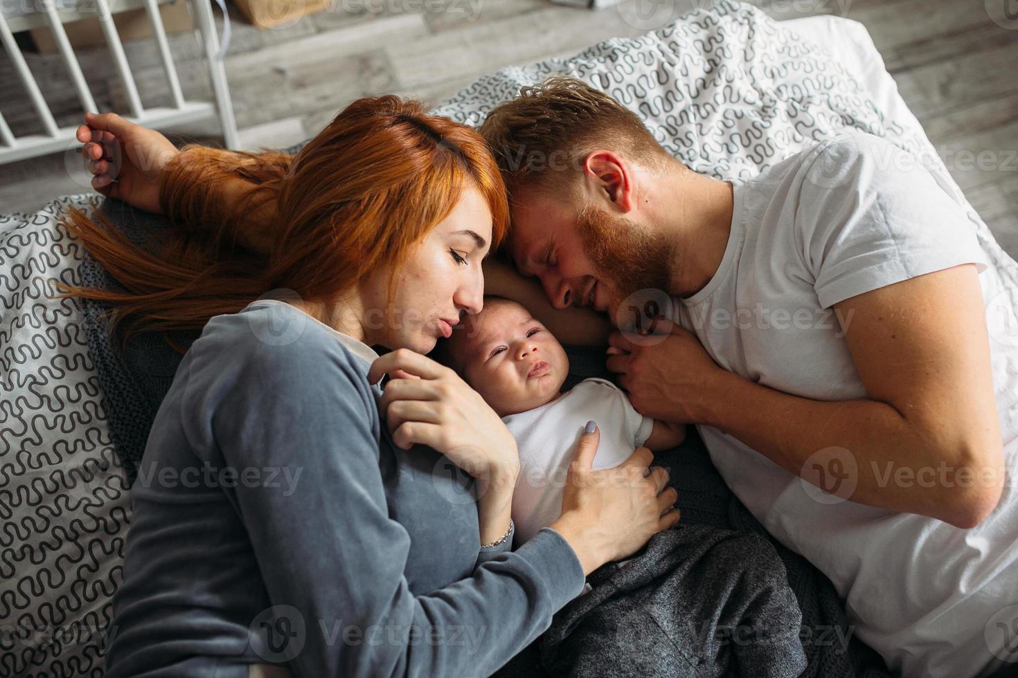 pais jovens dando atenção ao bebê. foto