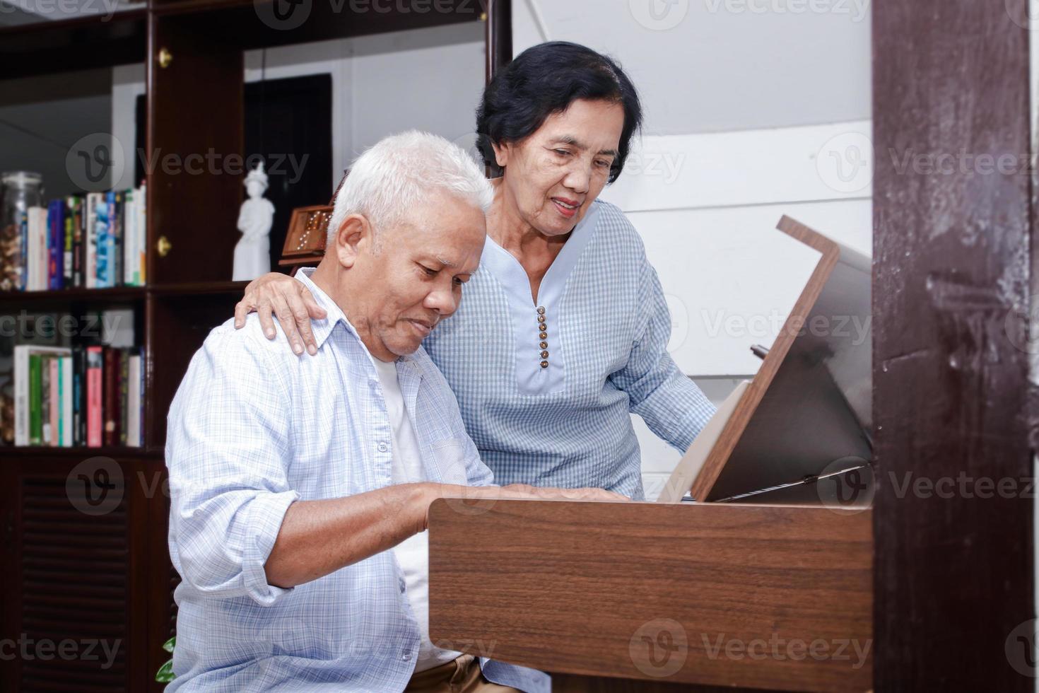casal de idosos asiáticos se diverte tocando piano elétrico juntos. conceito de comunidade sênior, cuidados de saúde foto