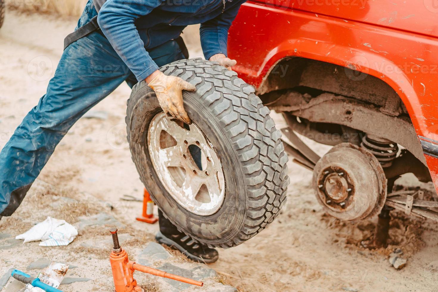 homem mudar a roda manualmente em um caminhão 4x4 off road foto