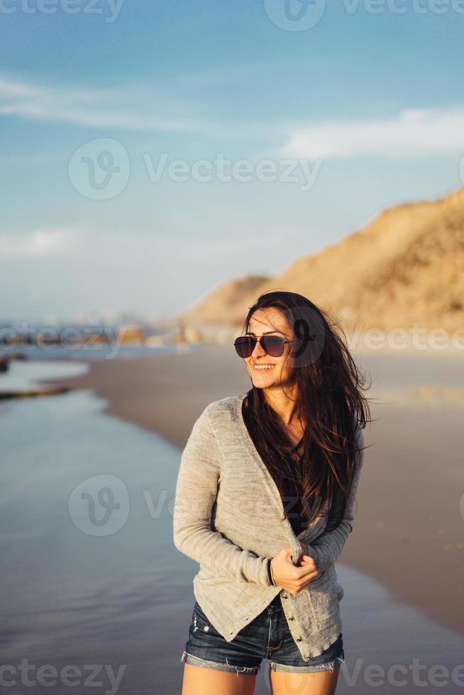 linda jovem posando à beira-mar foto