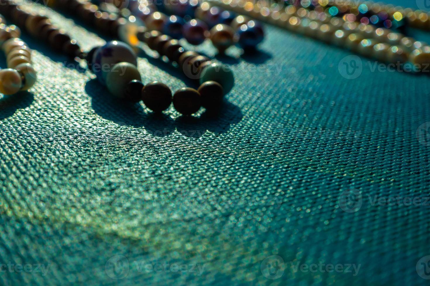 pilha de contas de joias coloridas brilhantes sobre um fundo azul. colar de contas de gemas diferentes. colar de joias padrão de moda moderna ou textura. copie o espaço. foto
