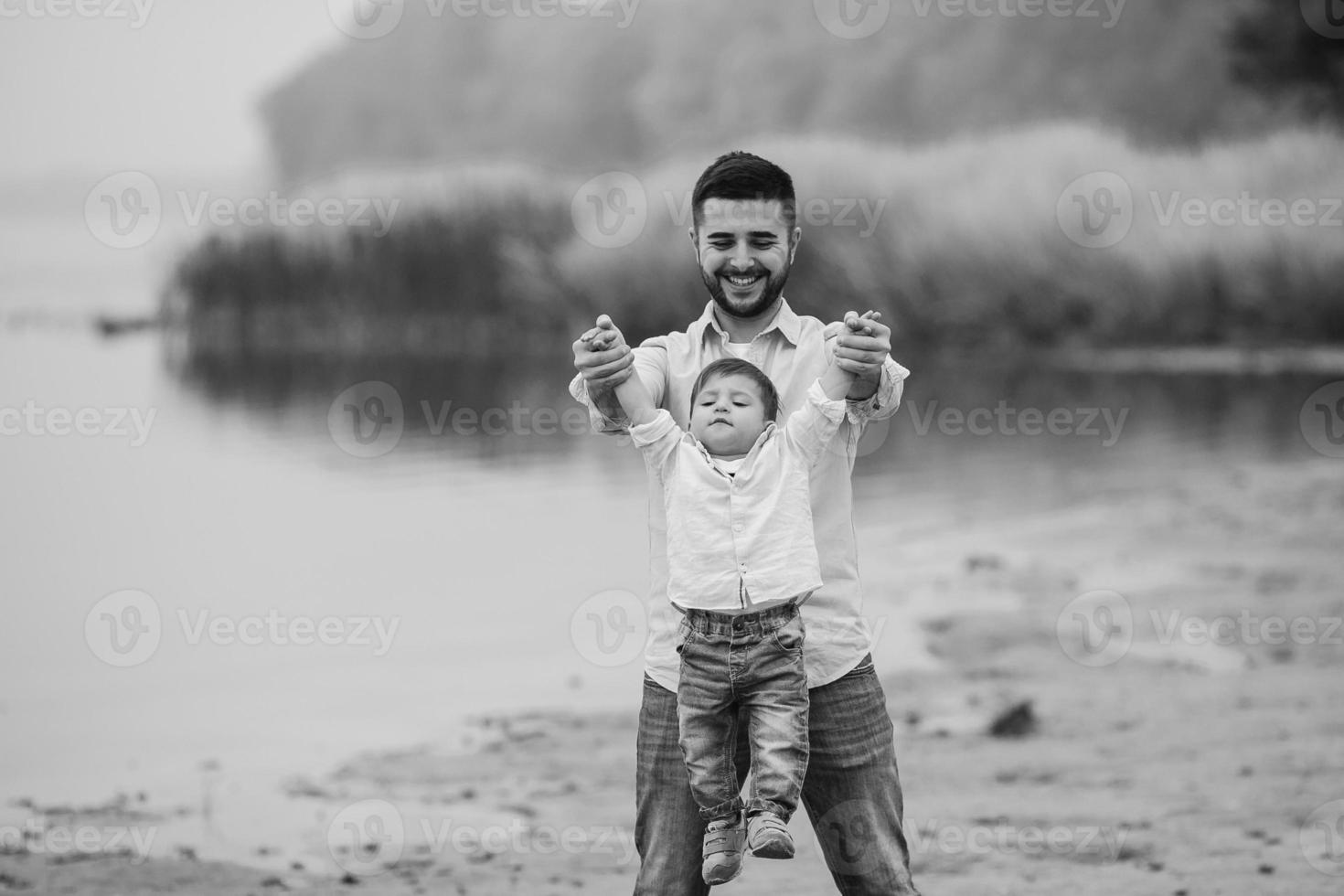 pai segurando as mãos do filho infantil foto