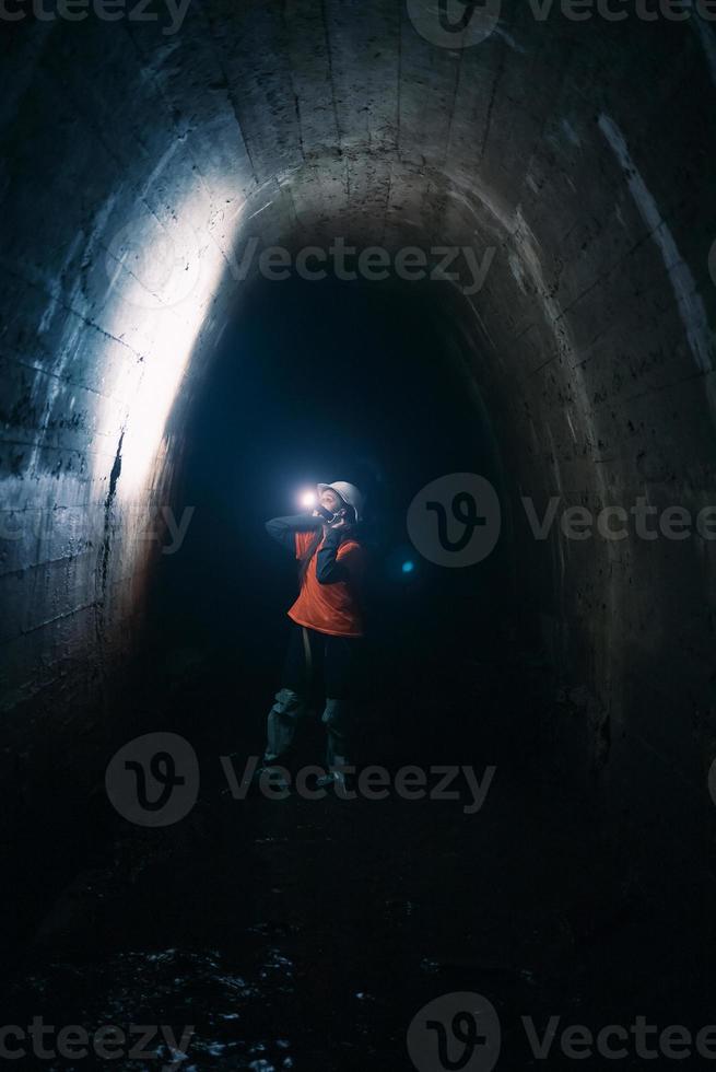 escavadora feminina com lanterna explora o túnel foto