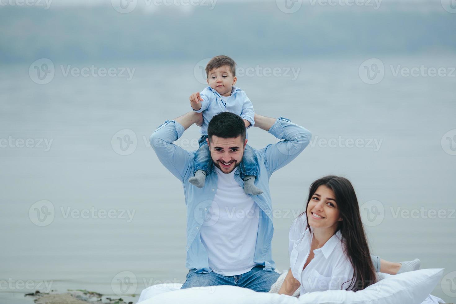 família jovem feliz relaxando juntos no lago foto