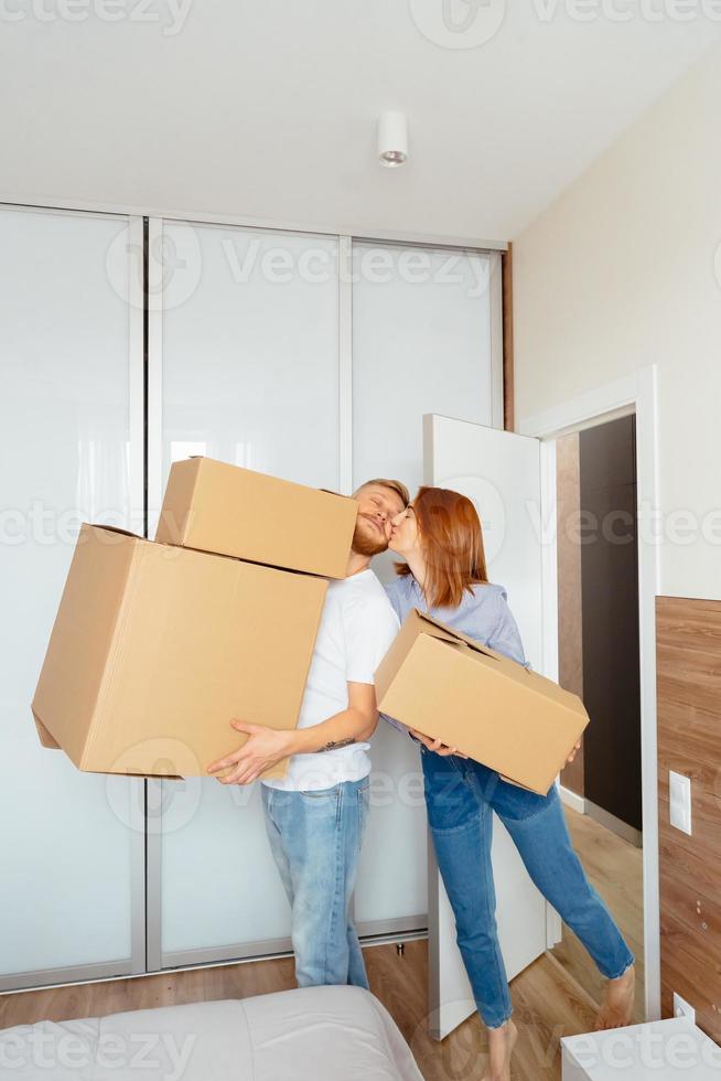 casal feliz segurando caixas de papelão e se mudando para novo lugar foto